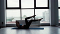 Beautiful young woman doing abs crunches in background of window in slow motion 54739554
