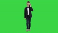 Little boy in a costume making a phone call while walking on a Green Screen, Chroma Key. 57199392