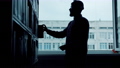 Silhouette of male student looking through books in university library reading 57933956