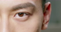 slow motion of male eye close up from asian young man half face 65860466