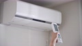 エアコンの電源をつける女性 67710502