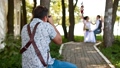 Professional wedding photographer taking pictures couple of newlyweds on a rope swing 74359695
