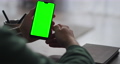 modern smartphone with chromakey on screen in hands of male user, sitting at table, swiping and 74805353