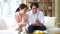 Young couple looking at a smartphone in the living room 76233284