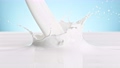 Super Slow Motion Shot of Pouring and Splashing Fresh Milk on Blue Background at 1000 fps. 78753354