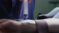 Patient inserts an intravenous catheter put into his arm in preparation for a surgery procedure. Reverse video 82190426