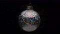 Beautiful shining Christmas ball hanging and spinning on black background. Closeup of single holiday New Year's ball. Motion blur. Soft and selective focus on foreground. 84678833
