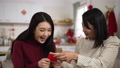 closeup of surprised daughter giving her mother a hug with smiling face while receiving red envelope lucky money during spring festival at home 84906256