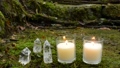Candles and crystals on mossy ground 85588147