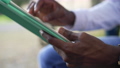 Close-up African American male hands with tablet surfing Internet messaging online. Unrecognizable young man sitting outdoors using app. Modern technologies and convenience concept. 85868323