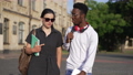 Dolly shot confident African American man and Caucasian woman walking outdoors talking at university campus. Interracial couple of groupmates discussing studies strolling on sunny morning at college. 85868329