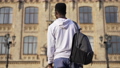 Back view African American young man standing on sunny morning outdoors walking to college campus. Intelligent confident male student at university building. Studying and lifestyle concept. 85868330