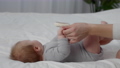 Unrecognizable Mother Playing With Cute Chubby Baby Lying On Bed At Home 85881788