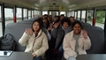 Cheerful multi-ethnic high school students waving hello and smiling while posing on camera during ride to study by school bus. Happy multinational secondary school pupils on school bus 86478152