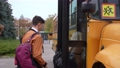Close-up of multi-ethnic high school students with backpacks taking turns to get on yellow school bus at the end of lessons. Multinational secondary school pupils boarding school bus one after another 86478485