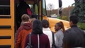 Back view of multi-ethnic high school students getting on yellow school bus after lessons. Group of diverse teenage secondary school pupils boarding school bus at the end of studies 86478492