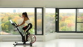 Exercise bike with wheels spinning. Woman exercising at home living room on indoor bicycle doing workout. Woman training on stationary bike watching online video class using training fitness app 86806205
