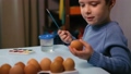 A little child paints an easter egg. 87236535