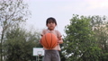 Cheerful cute girl playing basketball outdoors. 87694092