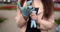 Putting disposable white gloves on park background 87892528