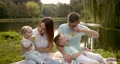 Young family with two children outdoors by the river on summer picnic 87892845