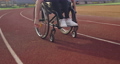 A female person with disabilities riding a wheelchair on a training track 87959193
