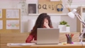 Asian woman sitting at desk in front of laptop stressed out face and headache shows her stressful  with work from home office. Female thinking about work mistake or workload has depression. 89723853