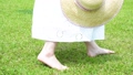 麦わら帽子を持って芝生を歩く女性の足元【パーツカット】 90955656