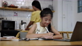 Asian mother teaching, helping daughter with homework while sitting at home kitchen. E-learning education concept 90990848