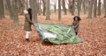 Autumn season. Two kids on a picnic, pretten black girls pputting a camping tent in an autumn forest. 92431933