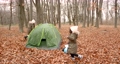 Autumn day at forest. Two girls walking on leaves and playing near a tent. Camping, weekend, little explorers. 92433262