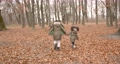 Autumn day at forest. Two girls walking on leaves and playing near a tent. Camping, weekend, little explorers. 92433264