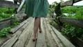 Women's legs go along the old wooden bridge. Close-up 92442172