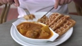 Man slicing and eating delicious waffles with curry chicken in a restaurant. Yummy fusion asian-western style food.  93188056