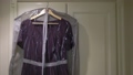 Purple festive women's dress hangs on hanger on a wardrobe in the dressing room. 93479993