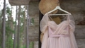 Wedding dress, pink bridal gown hanging on hanger outdoors. 93479996
