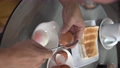 Vertical video of man cracking open a half boiled egg with a spoon. Toast bread at the background. Healthy breakfast concept. Close up view. 93815785