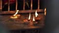 Close up view of a diya oil lamp candle burning and glowing on a table in temple. 93815786