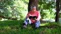 Happy Asian old senior man with gray hair reading book outside in park. Concept of happy elderly man after retirement and good health 94442436