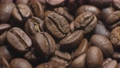 Aromatic fresh brown coffee beans close-up. slow motion over roasted sunflower seeds in a shot. Organic flavor ingredient for caffeinated drink. Background of coffee beans. 94578652