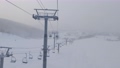 降雪で視界の悪いスキー場をゴンドラリフトから見下ろす (北海道、ニセコ) 94703605