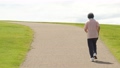 公園でウォーキング・有酸素運動する高齢者女性の後ろ姿 94834603