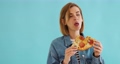 young woman eating pizza slice and looking delighted 95443549