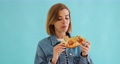 young woman eating pizza slice and looking delighted 95571345