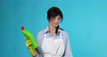woman in gloves and apron chooses between two cleaning products 95571346
