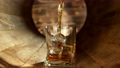 Super Slow Motion Shot of Pouring Whiskey into Glass with Ice Cubes inside Wooden Barrel at 1000fps. 96485592