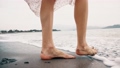 Barefooted young woman stepping on a wet black beach, slow motion close-up shot 96613041