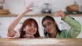Two beautiful women play with flour in the kitchen 96706752