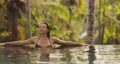 Bikini Woman in a Tropical Open-air Infinity Swimming Pool during Summer Tropical Vacation in Luxury Villa 96907361