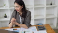 American Woman looking stressed while using laptop with financial document on table. Woman work from home 98056470